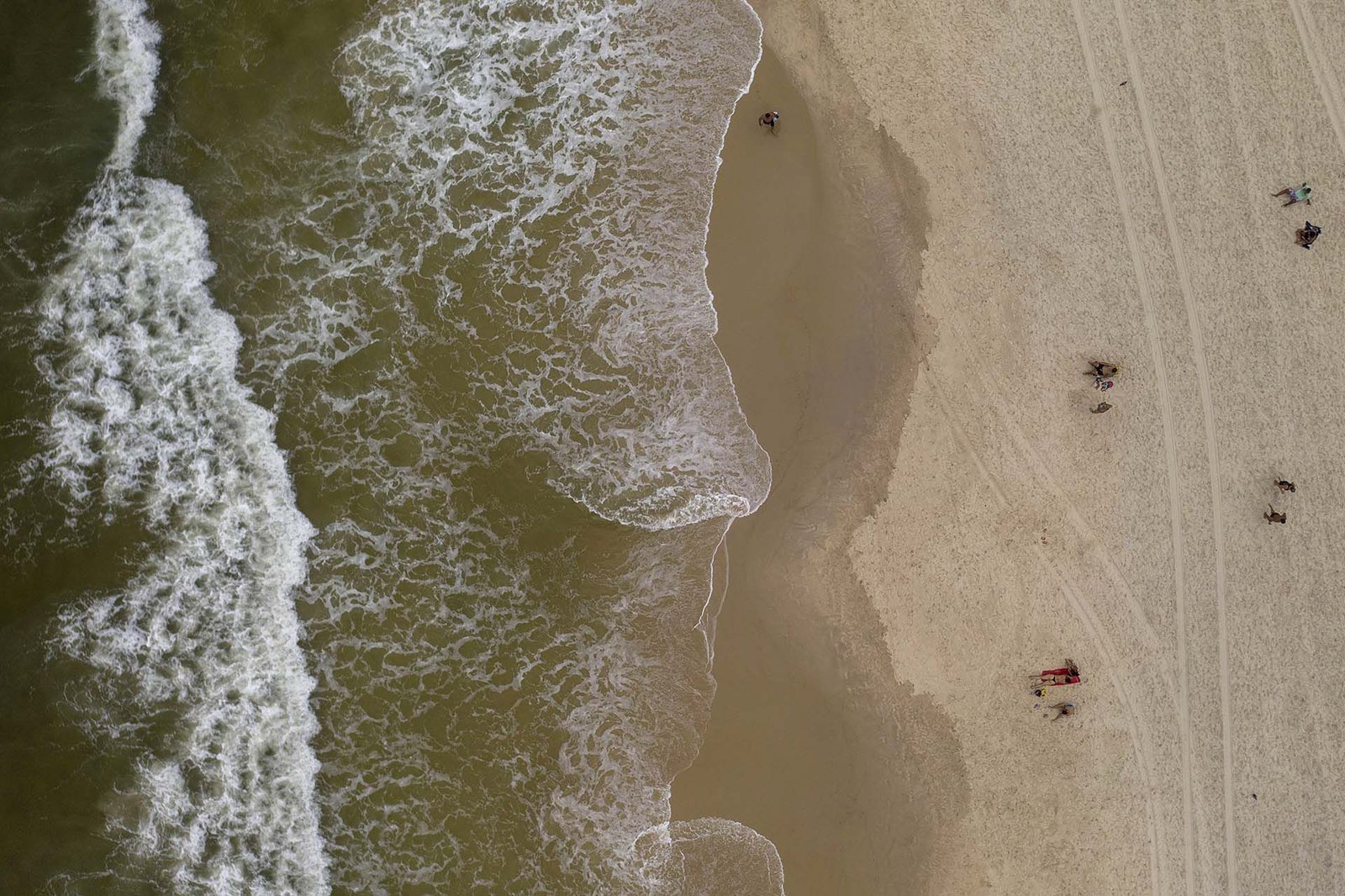 Unas pocas personas en la playa de Arpoador en Rio de Janeiro, Brasil. 
