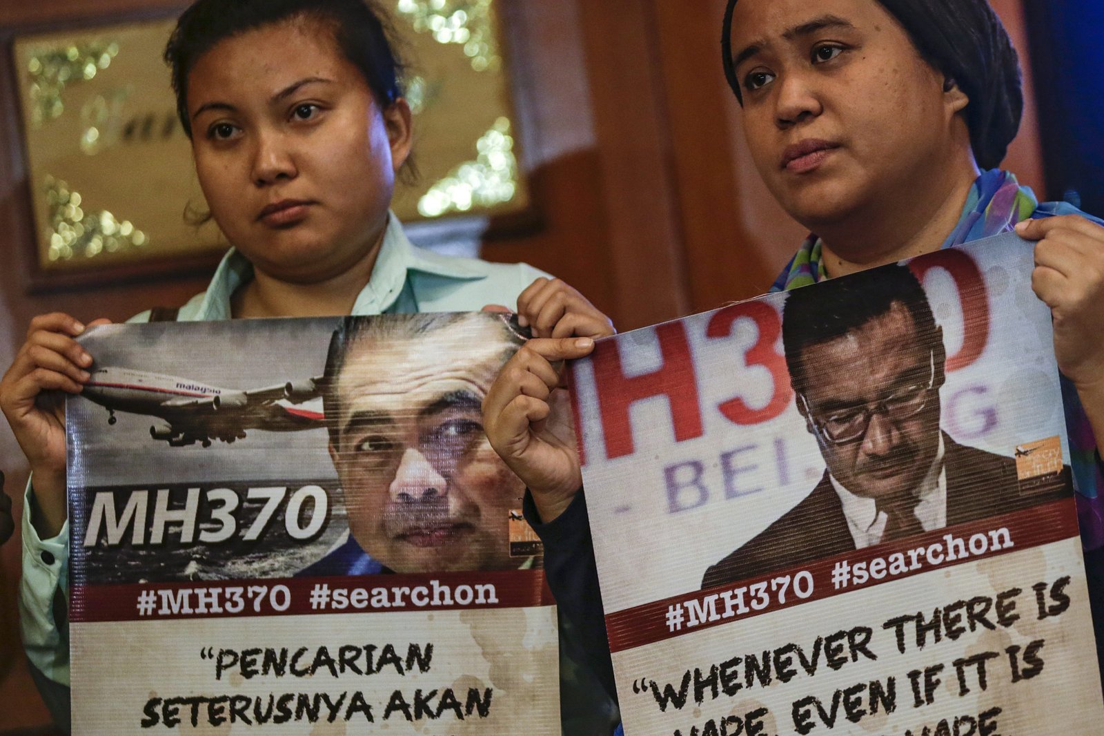 Asistentes muestran carteles de los desaparecidos del vuelo MH370. EFE/Fazry Ismail 