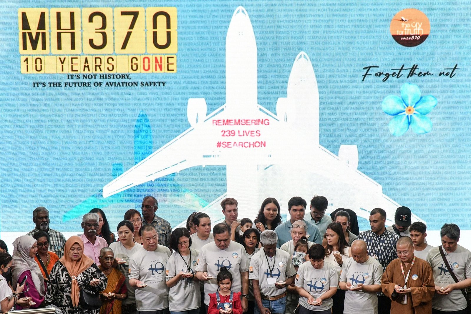 Familiares de los pasajeros y la tripulación a bordo del desaparecido vuelo MH370 de Malaysia Airlines y el ministro de Transporte de Malasia, Loke Siew Fook (en el centro), se reúnen para una foto de grupo durante una evento conmemorativo del décimo aniversario de su desaparición en el Empire Subang en Subang Jaya, en Malasia. EFE/EPA/MOHAMAD NAZRI 