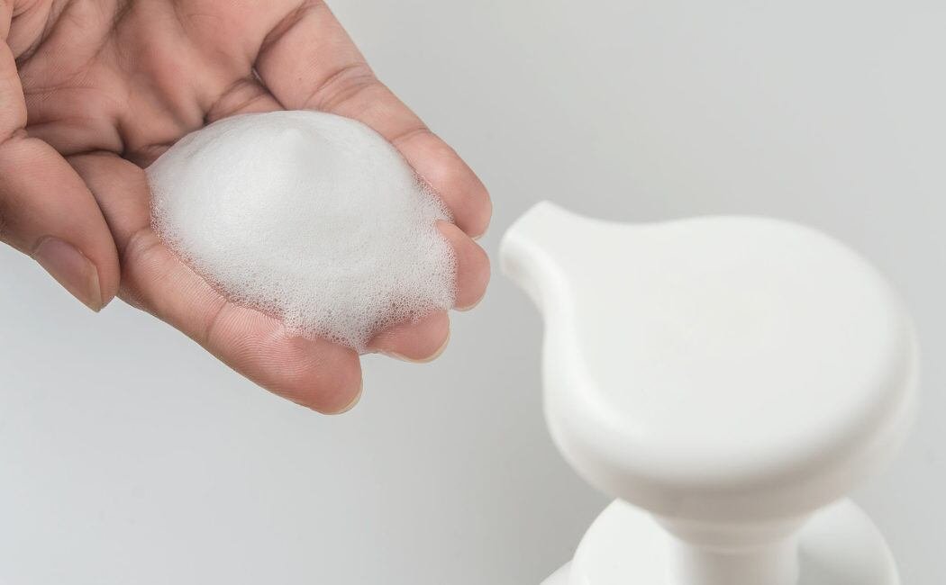 Una mano de mujer con un poco de jabón líquido en los dedos - Vulvovaginitis (Bekia Salud)